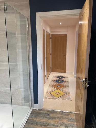 a hallway with a glass door and a rug at Carbis Bay Suite, Carbis Bay, St Ives, free parking, near beach in Carbis Bay
