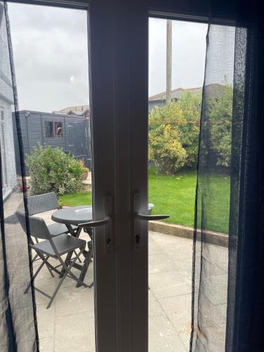 a door to a patio with a table and a chair at Carbis Bay Suite, Carbis Bay, St Ives, free parking, near beach in Carbis Bay
