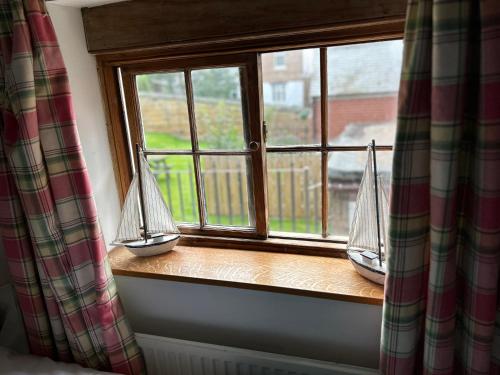 a window with two ships on a window sill at Saltwick Cottage in Whitby