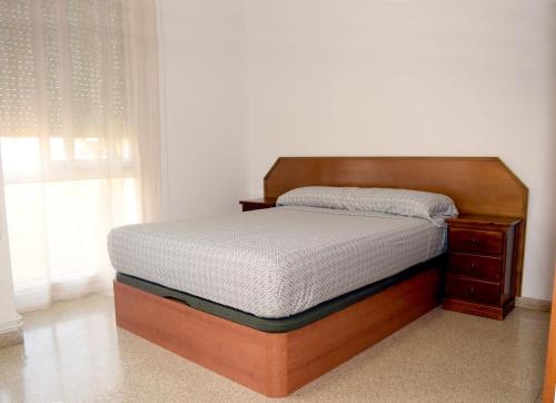1 cama en un dormitorio con marco de madera en Apartamentos Atlas Terrassa IV (Les Escoles) en Terrassa
