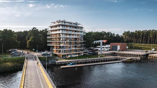 a tall building next to a body of water at Lighthouse, Sun & Snow in Mrzeżyno
