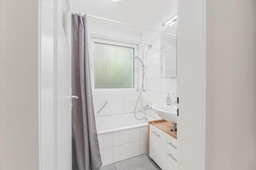 a white bathroom with a tub and a sink at NT01 schönes Appartement - ideal für Teams Self Check-In in Nürtingen