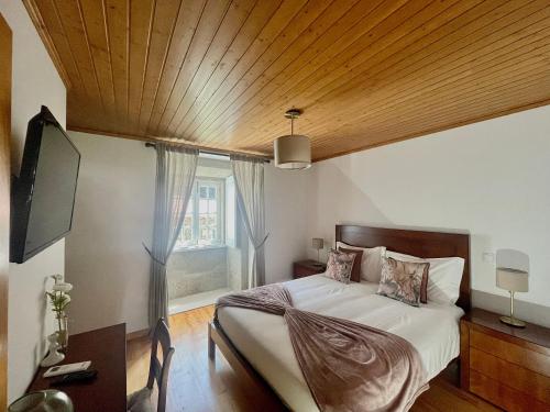 una camera con un grande letto e un soffitto in legno di Casa de Simaens a Felgueiras