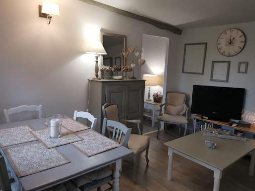 ein Wohnzimmer mit Tischen und Stühlen sowie einem TV in der Unterkunft le cabanon tendance du Luberon in Mérindol
