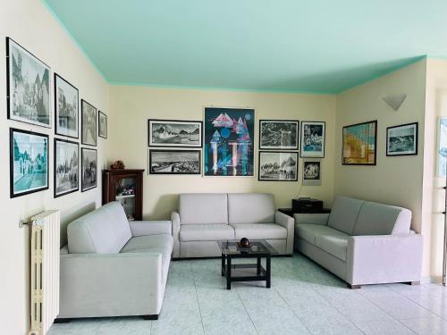a living room with two couches and pictures on the wall at Hotel Airone in Alberobello