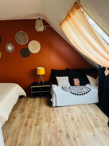 une chambre avec deux lits dans une pièce aux murs orange dans l'établissement MS Duplex, à Corbeil-Essonnes