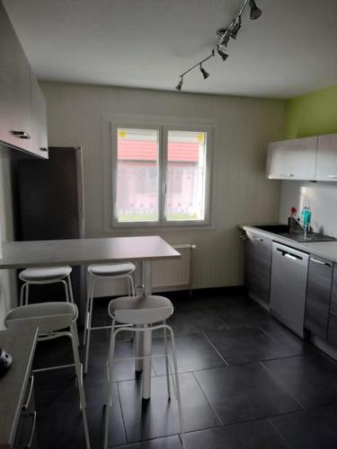 une cuisine avec une table et des chaises dans l'établissement Maison de vacances, à Appenwihr