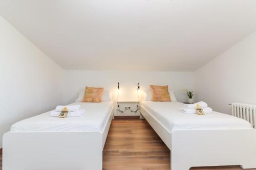 twee bedden in een kamer met witte muren en houten vloeren bij Chalet para 12 personas con piscina en Illescas Toledo in El Viso de San Juan