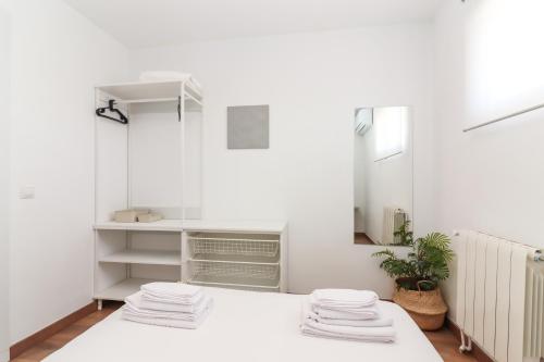 - une salle de bains blanche avec des serviettes sur une table blanche dans l'établissement Chalet para 12 personas con piscina en Illescas Toledo, à El Viso de San Juan