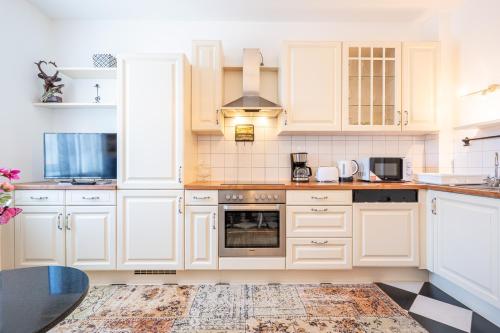 a kitchen with white cabinets and a stove at Apartment "Deluxe" Innsbruck - Mutters in Innsbruck