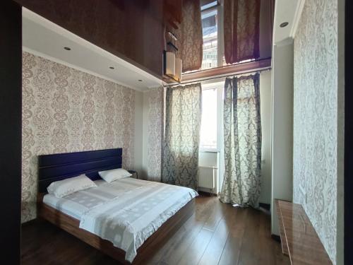 sypialnia z dużym łóżkiem i oknem w obiekcie Apartments on Rudanskogo w Kijowie