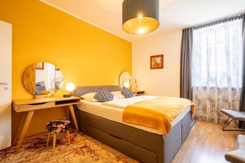 - une chambre avec un lit, un bureau et un miroir dans l'établissement Apartment "Deluxe" Innsbruck - Mutters, à Innsbruck