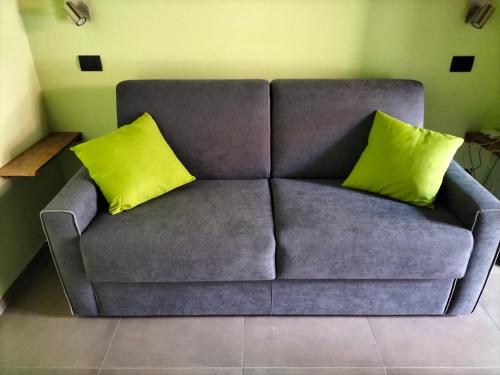 a couch with two yellow pillows in a living room at La cascina della vigna del viandante in Abbadia Lariana