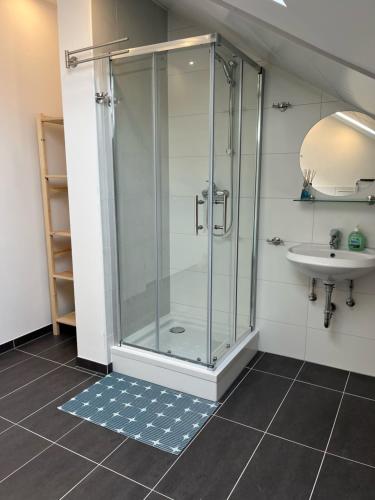ein Bad mit einer Dusche und einem Waschbecken in der Unterkunft Übernachtung by Tag in Staufenberg
