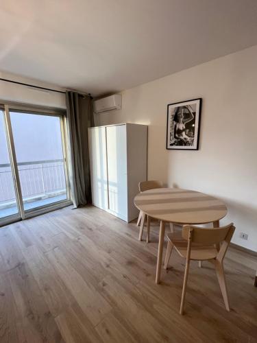 une salle à manger avec une table et un réfrigérateur dans l'établissement Studio neuf et central, à Antibes