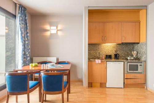 パス・ダ・ラ・カザにあるPierre & Vacances Pas de la Casa Alaskaのキッチン(テーブル、青い椅子付)