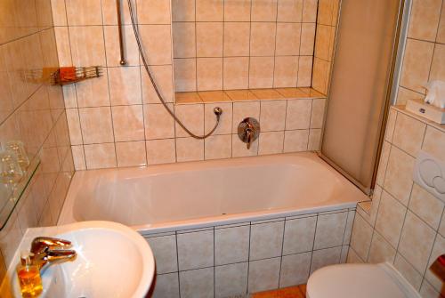 a bathroom with a sink and a tub and a toilet at Alexandra Alber Villa Schlosskopf in Sankt Anton am Arlberg