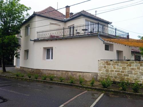 Casa blanca con balcón en la parte superior. en Centrum Villa Szolgáltatóház, en Tokaj