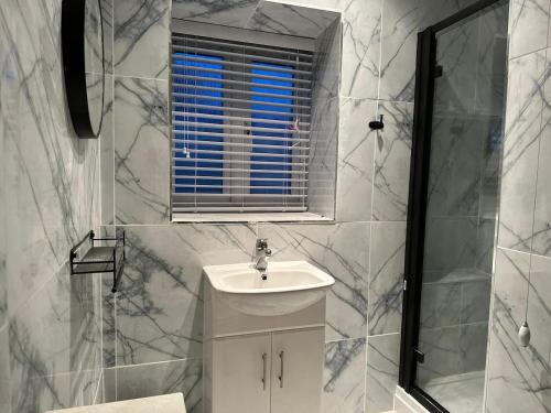 uma casa de banho branca com um lavatório e uma janela em Amazing 2 Bedrooms House em Bridgend