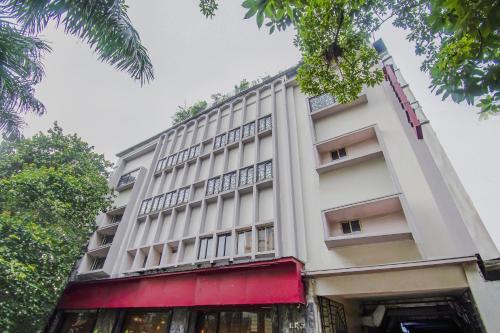 a large white building with a red awning at Mg Guest House in Kolkata