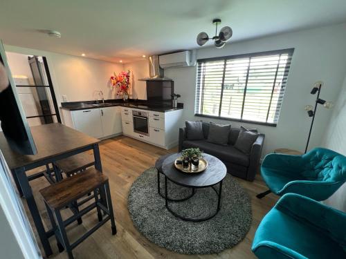 a living room with a couch and a table at Luxe woning ‘BARNS’ Castricum aan Zee + airco + parkeren in Castricum