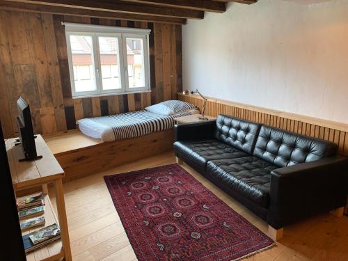 a living room with a leather couch and a bed at Hausele in Sulzbach an der Murr