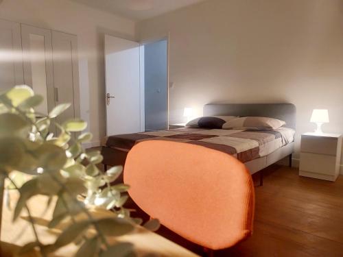 ein Schlafzimmer mit einem Bett und einem orangenen Stuhl in der Unterkunft Maison de charme in Toulouse