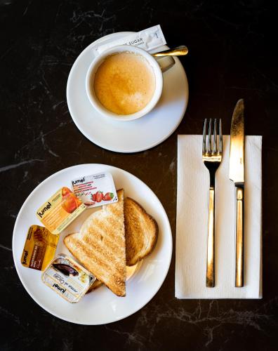 a table with two plates of food and a cup of coffee at Ta' Tereza In Manwel Dimech in Sliema
