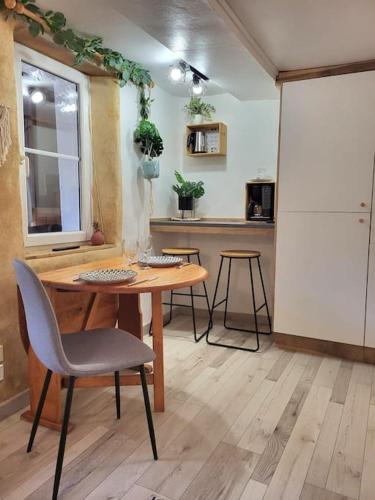 une cuisine avec une table, des chaises et un réfrigérateur dans l'établissement Maison cosy, à Laval