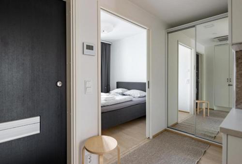 a bedroom with a bed and a glass door with a mirror at 2ndhomes Tampere "Lumilinna" Apartment - 1BR New Apt in the Heart of the City in Tampere