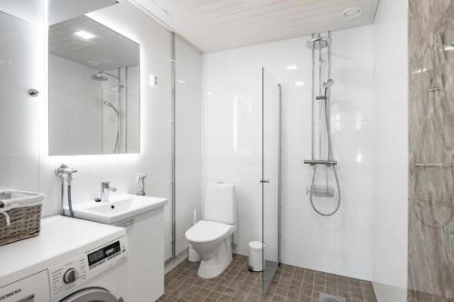 a bathroom with a toilet and a shower and a sink at 2ndhomes Tampere "Lumilinna" Apartment - 1BR New Apt in the Heart of the City in Tampere
