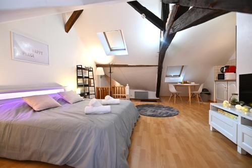 a bedroom with a large bed and a table at Le Cosy du tambour d'argent in Sens