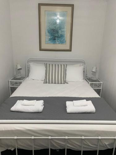 - une chambre avec un lit et 2 serviettes dans l'établissement Aruma Cottage Bruny Island, à Alonnah