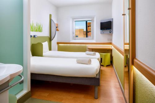 a hospital room with two beds and a sink at ibis budget Beaconsfield in Beaconsfield