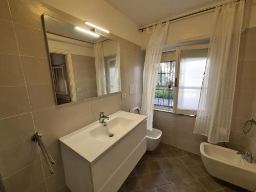 a bathroom with a sink and a toilet and a mirror at Il Nespolo in Misano Adriatico