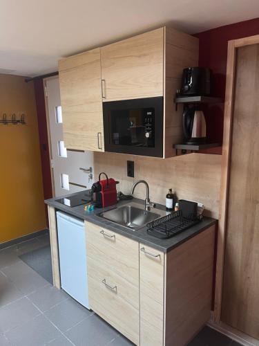 una pequeña cocina con fregadero y microondas en Suite avec Sauna 36m², en Niort