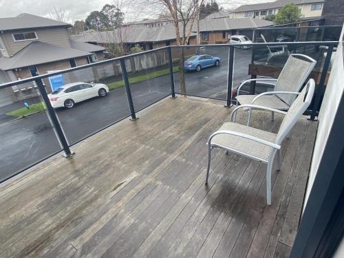 a balcony with two chairs and a view of a parking lot at Hamilton Hospital Retreat - 2 Bedroom Townhouse Modern Warm Quiet in Hamilton