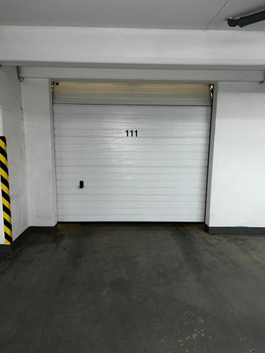 a garage with two white garage doors with the number at Donovaly Residence Apartment 111 in Donovaly
