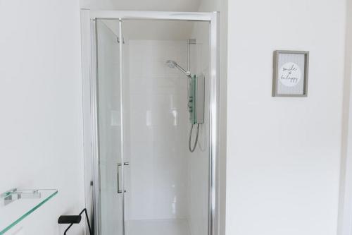 a shower with a glass door in a bathroom at APPLECROFT - Escape to the Peak District National Park in Buxton