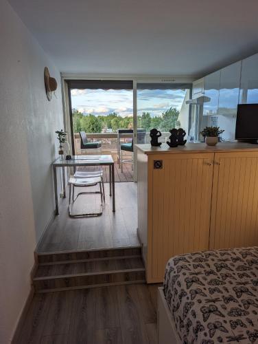 Cette chambre comprend un lit, une table et une cuisine. dans l'établissement Studio avec terrasse Heliopolis, au Cap d'Agde