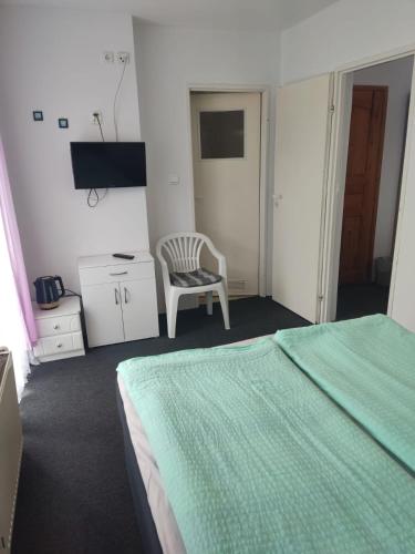 a bedroom with a green bed and a chair at Pokoje Gościnne U Dany in Jarosławiec