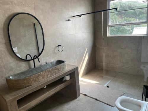 a bathroom with a sink and a mirror and a toilet at Villa 9B Signal Hill Ponta Malongane in Ponta do Ouro