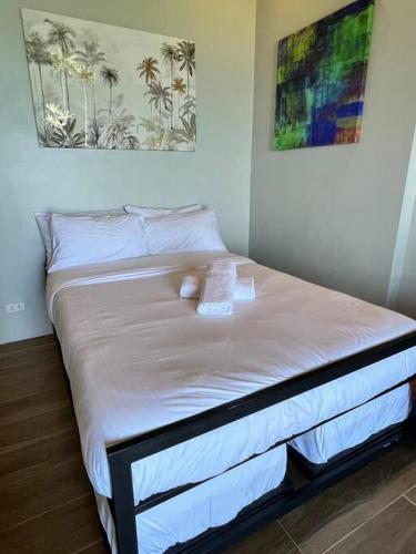 a bed in a room with a white bedspread at Modern Unit Near The Beach at Canyon Cove Nasugbu in Nasugbu