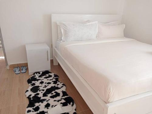 a bed with a black and white cow rug on the floor at Exquisite 1br Apartment along Eldoret-Kisumu Road close to Eldoret Polytechnic in Eldoret