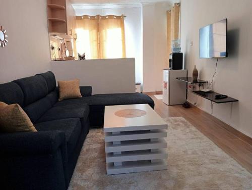 a living room with a couch and a coffee table at Exquisite 1br Apartment along Eldoret-Kisumu Road close to Eldoret Polytechnic in Eldoret