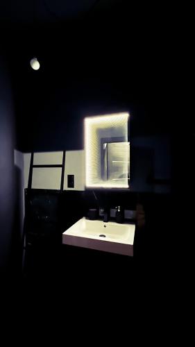 a bathroom with a white sink and a mirror at BDSM Red Room Apartment in Łódź