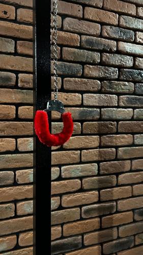 a red teddy bear hanging on a chain at BDSM Red Room Apartment in Łódź