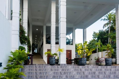 a building with stairs and potted plants at Zodiak in Tangalle