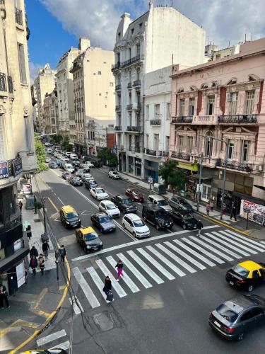 a busy city street with a lot of cars parked at Refugio Francés en Buenos Aires in Buenos Aires