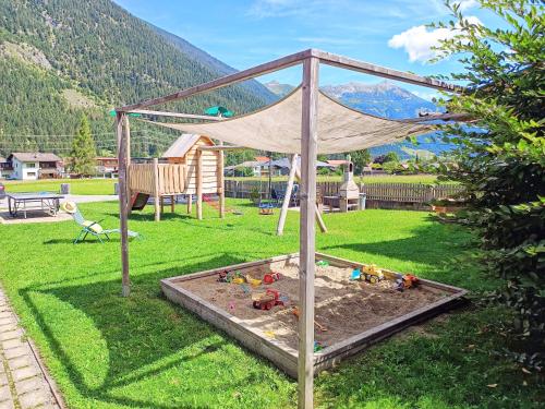 a sandbox in a yard with toys in it at Luxury Chalets Wiesenruh in Bichlbach